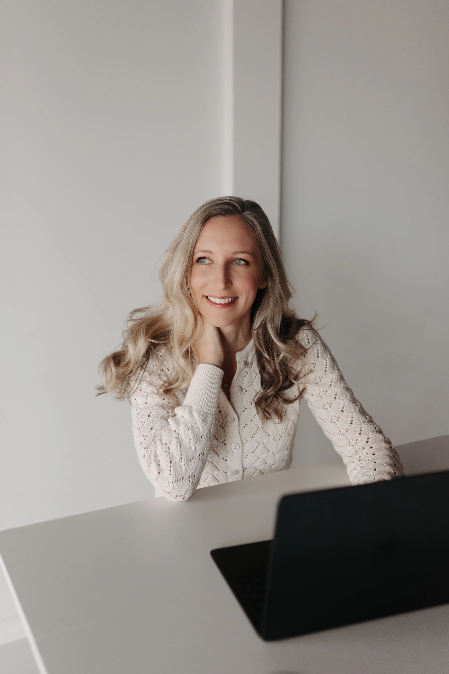 Therapist smiling at a desk during an online session